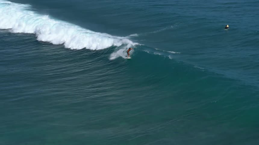 An aerial view of two men surfing in the ocean