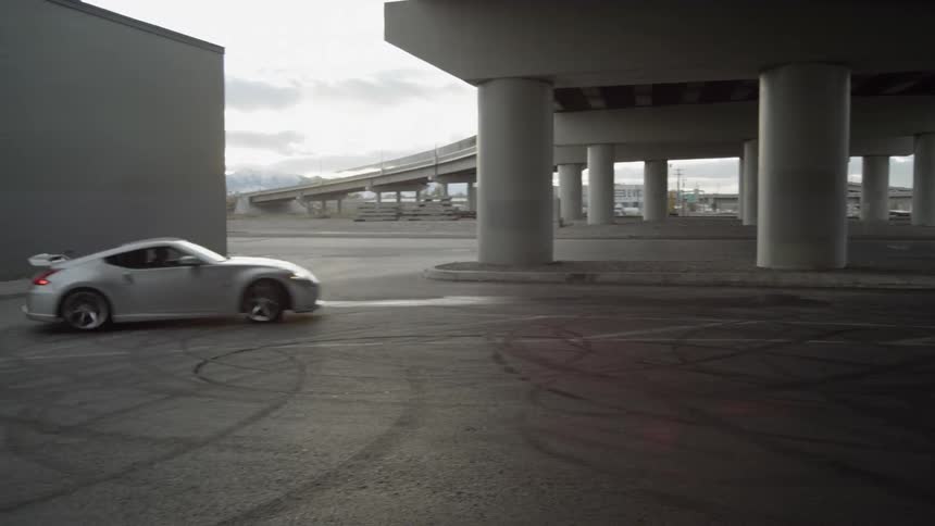 A car drifts into a circle under an overpass