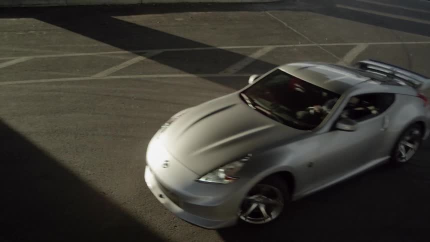 A sports car drifts across a parking lot
