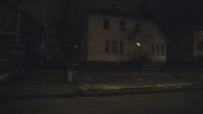 Houses and cars in a neighborhood as soon from a car driving down the street