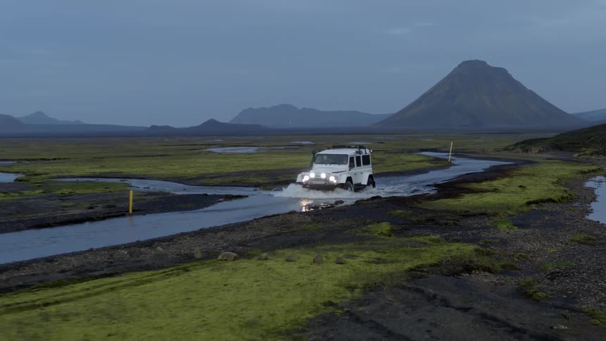 A car is driving off road in a wetland area