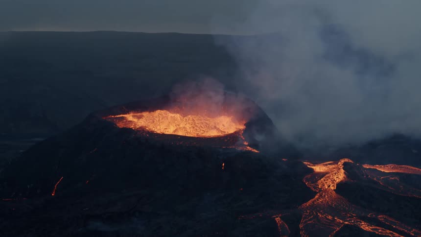 Lava glows from an erupting volcano
