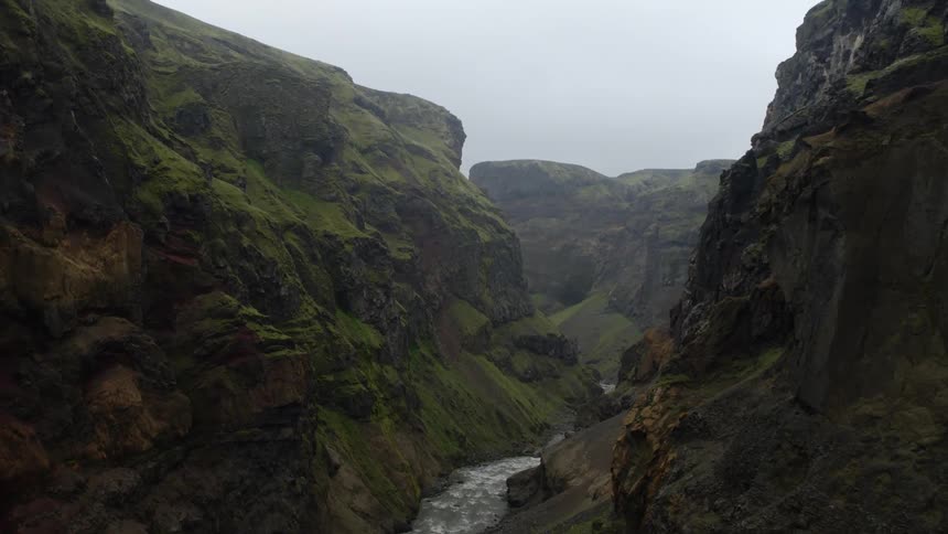 A narrow river runs between steep canyon walls