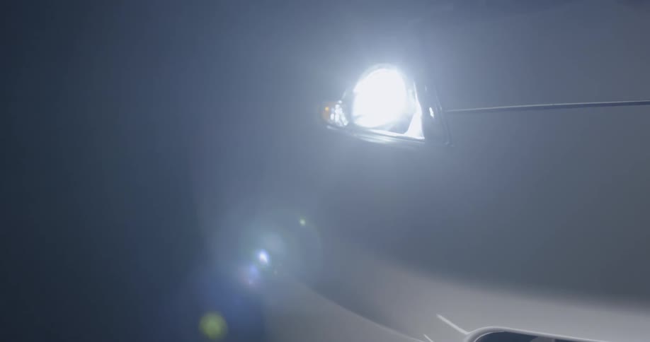 A sports car's light shines at night