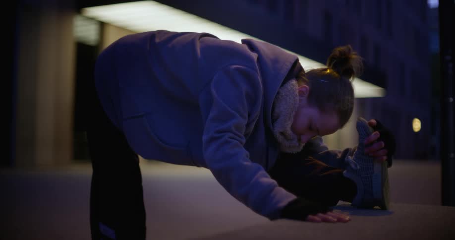 A woman leans forward and extends stretching her leg