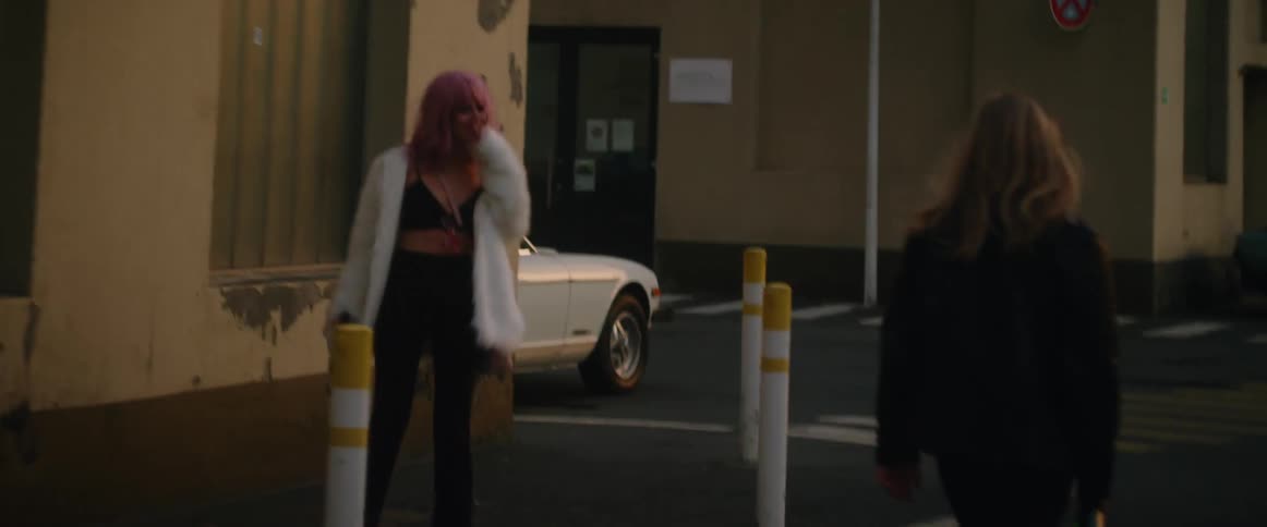 Young couple playfully walking on the empty city streets at morning after a party