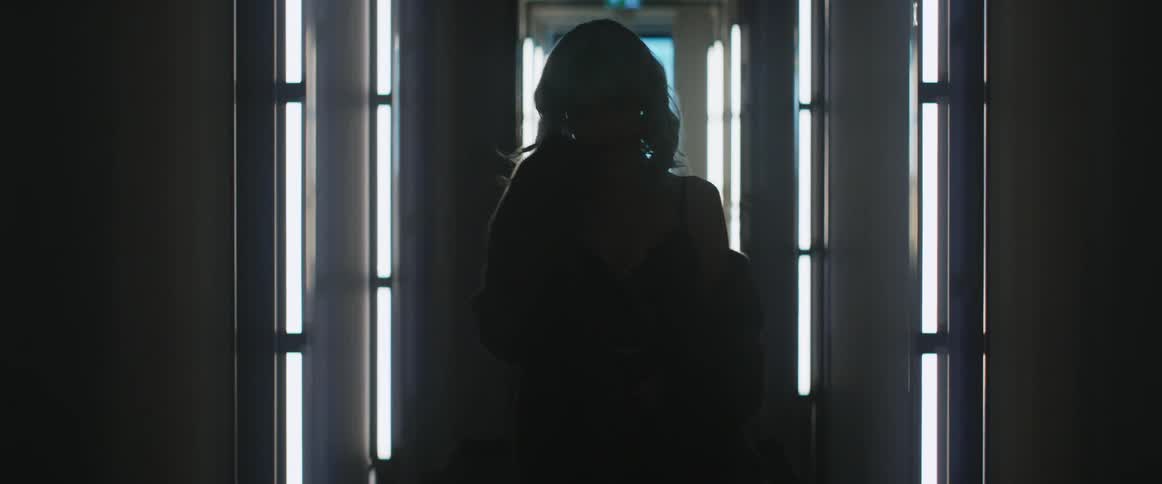 A fashion model is walking in a room
