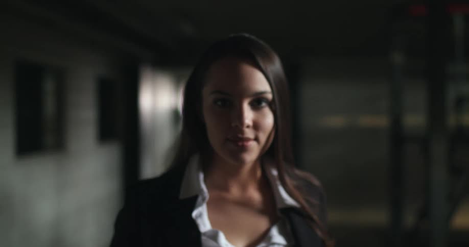 A woman smiles and poses while standing in an office building