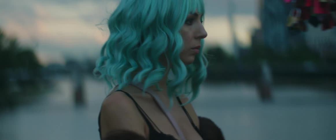 A woman walks through an urban neighborhood while wearing a colored wig