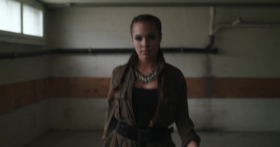 Fashion model walks along concrete floor in empty room