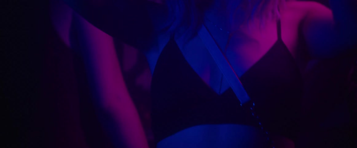 A woman dances with other people in a night club