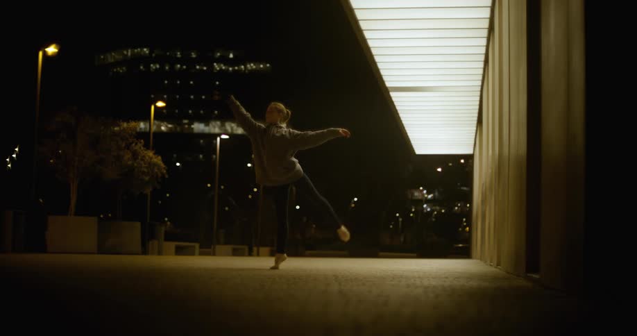 Dancer moves through steps outdoors at night in the city