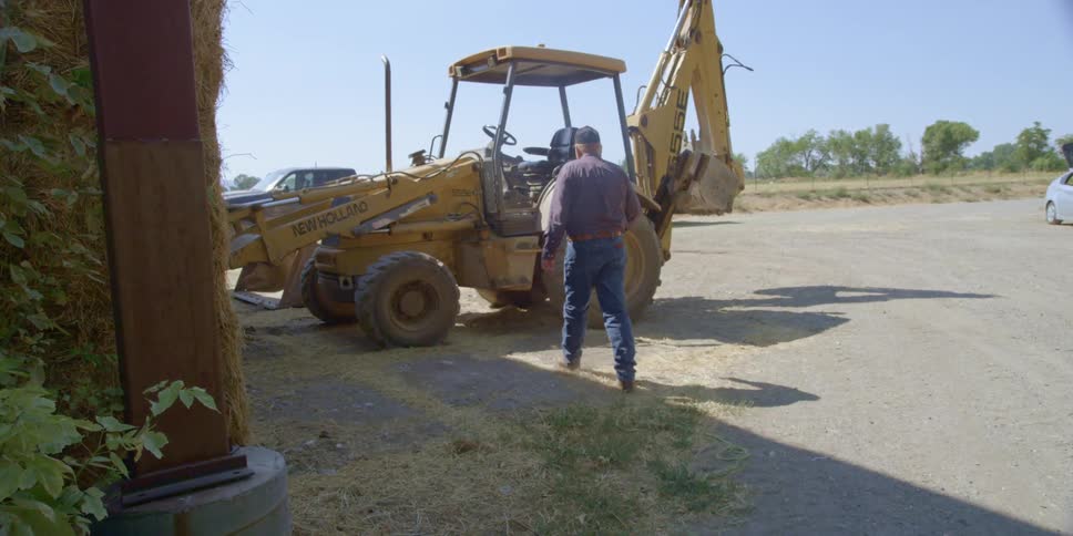 A man climbs into a backhoe