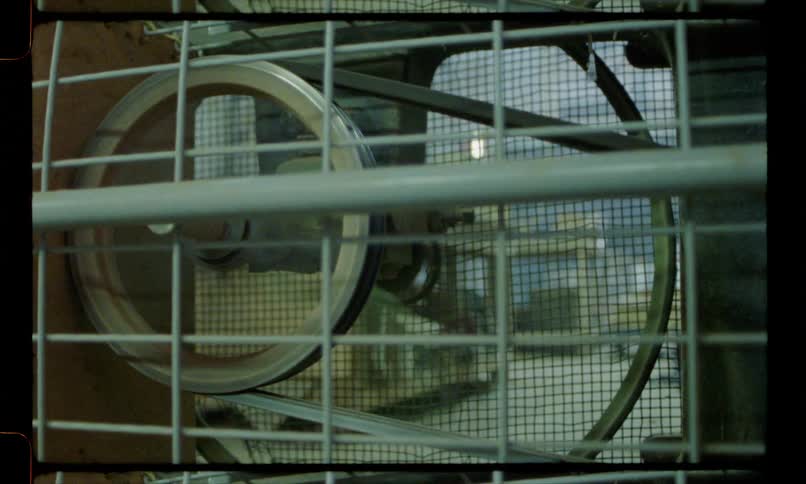 An exhaust fan starts up spinning behind a grate
