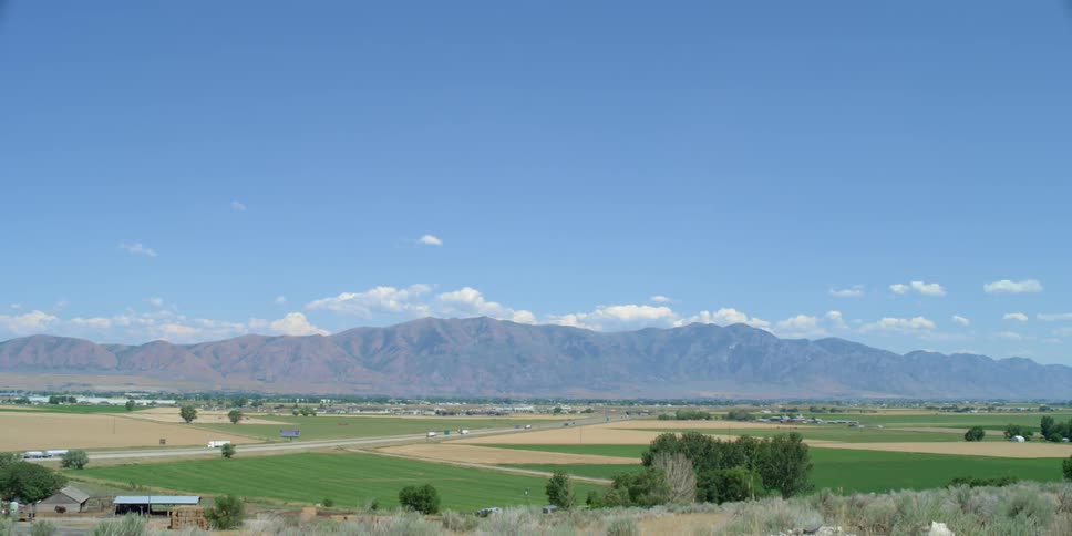 Traffic along a rural road near a mountain range