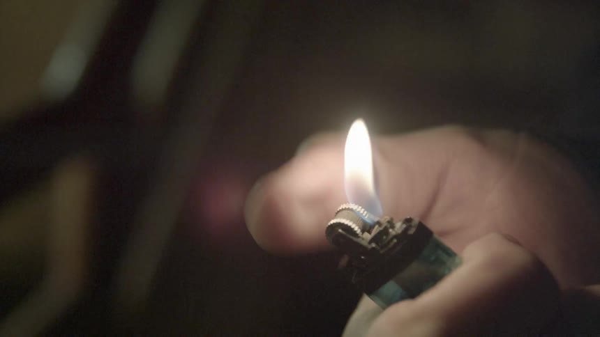 A person flicks a lighter turning it on