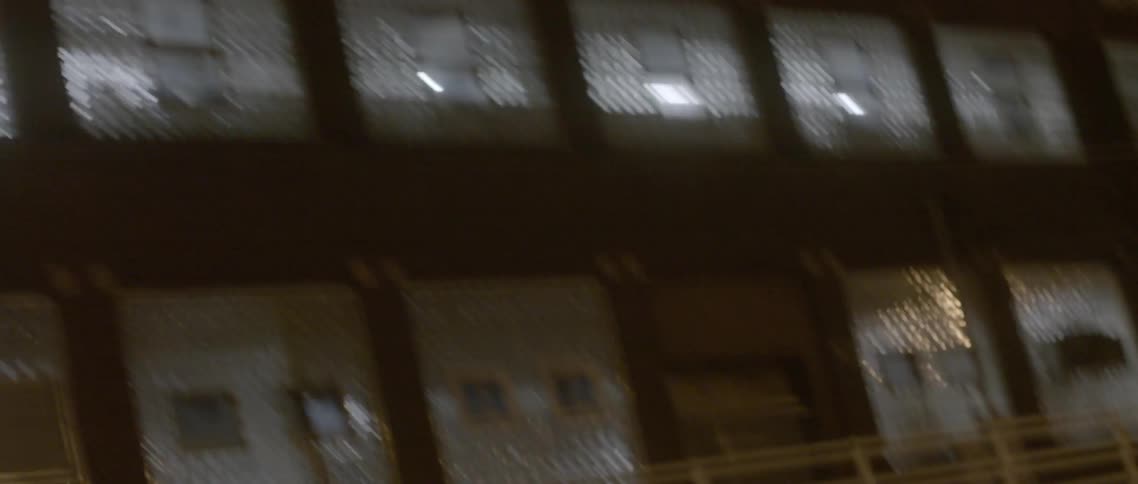 Unsteady, back and forth view of outside of a building at night