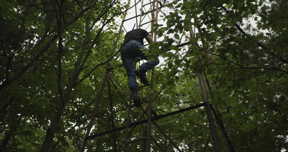 A man is climbing down the ladder