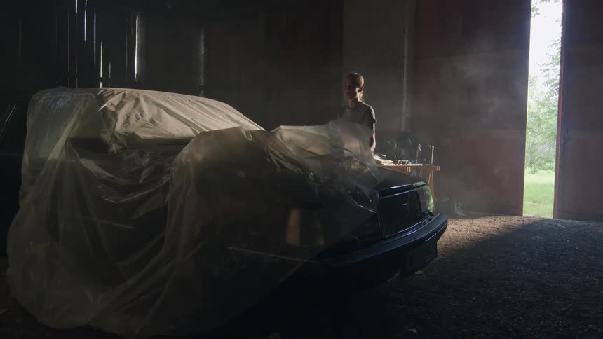 A woman removes the cover from her car