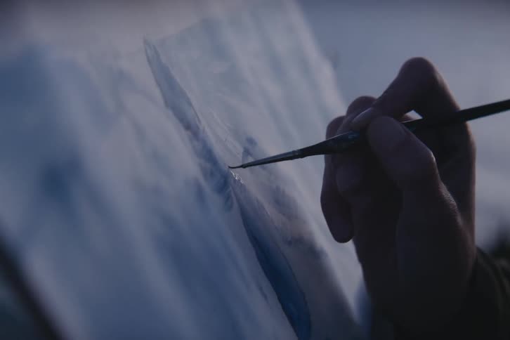 The hand of a person as they paint a picture
