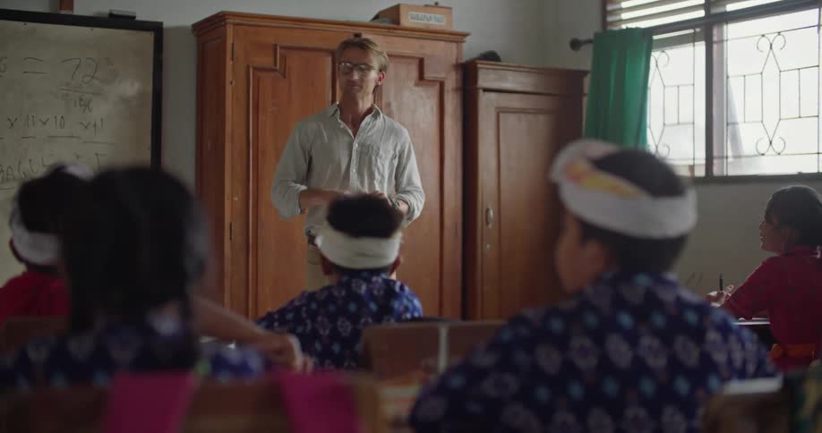 A teacher chats with students in the classroom