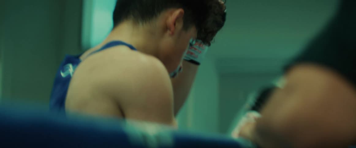 A boxer removes his gloves and headgear
