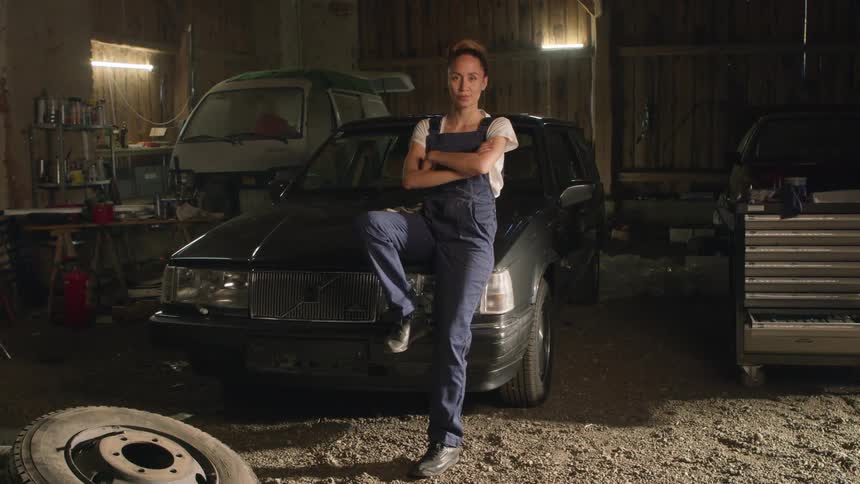 A mechanic sits on the car