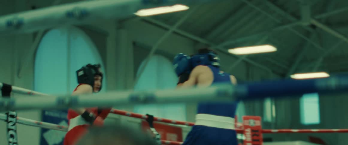 There are two people that are boxing each other inside of a boxing ring