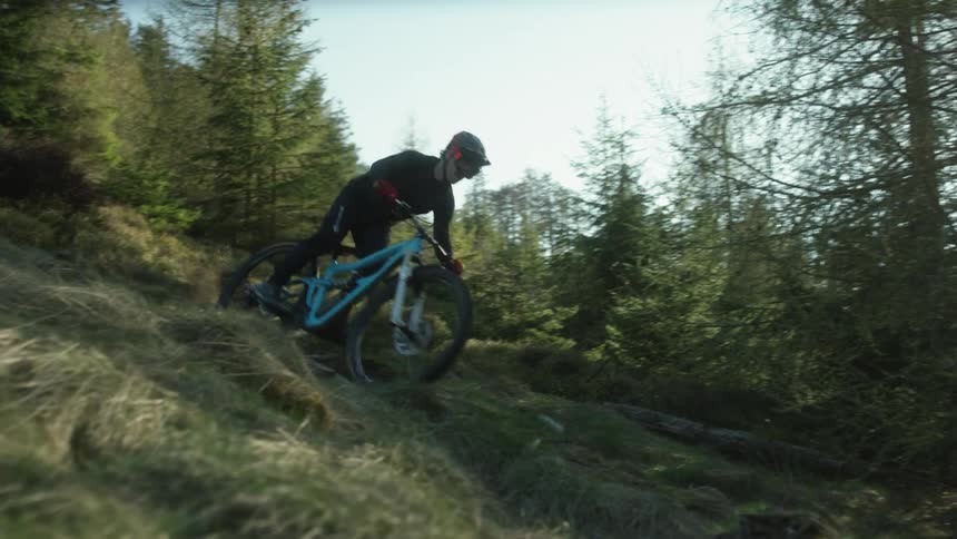 A man rides his mountain bike downhill
