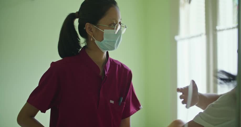 A doctor is examining a woman who is hooked to an iv