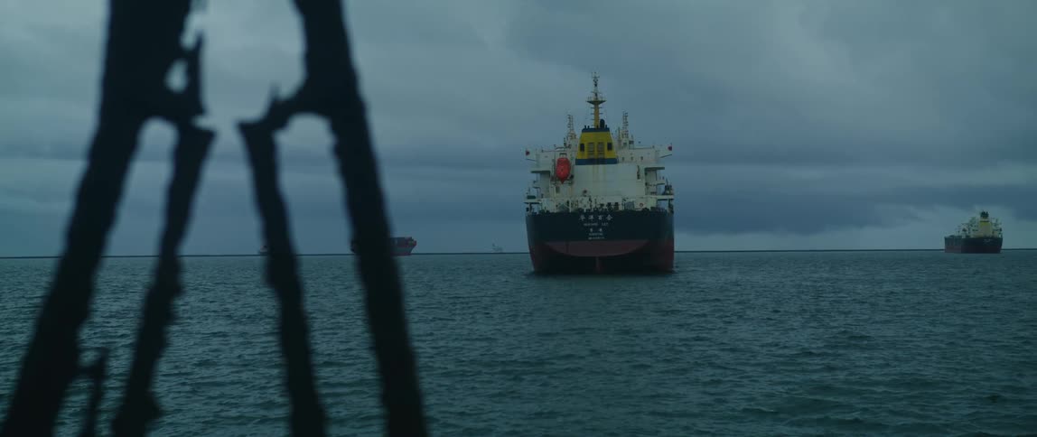 There is ships that are on an ocean in the middle of the day time