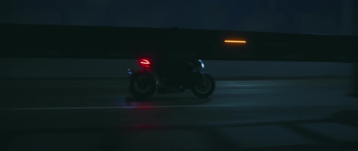 The motorcycle drives over the bridge
