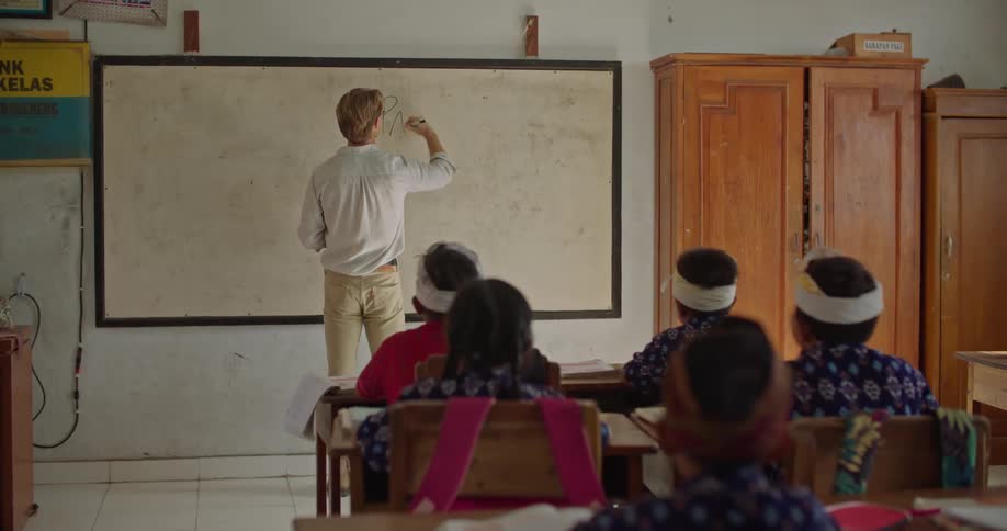 There is a teacher teaching kids inside of a classroom
