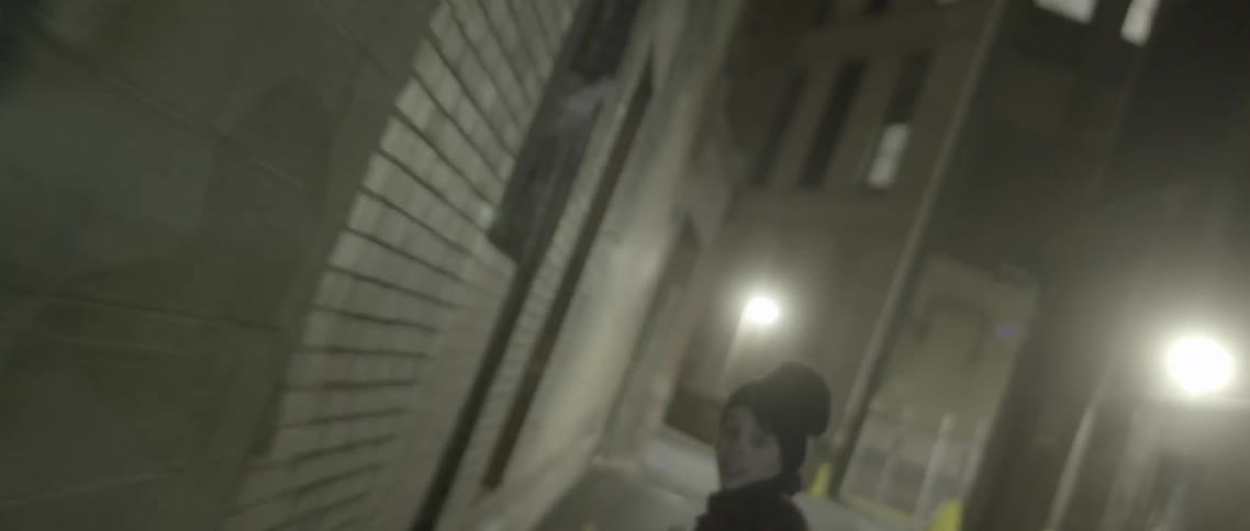 A boy runs down a dark street