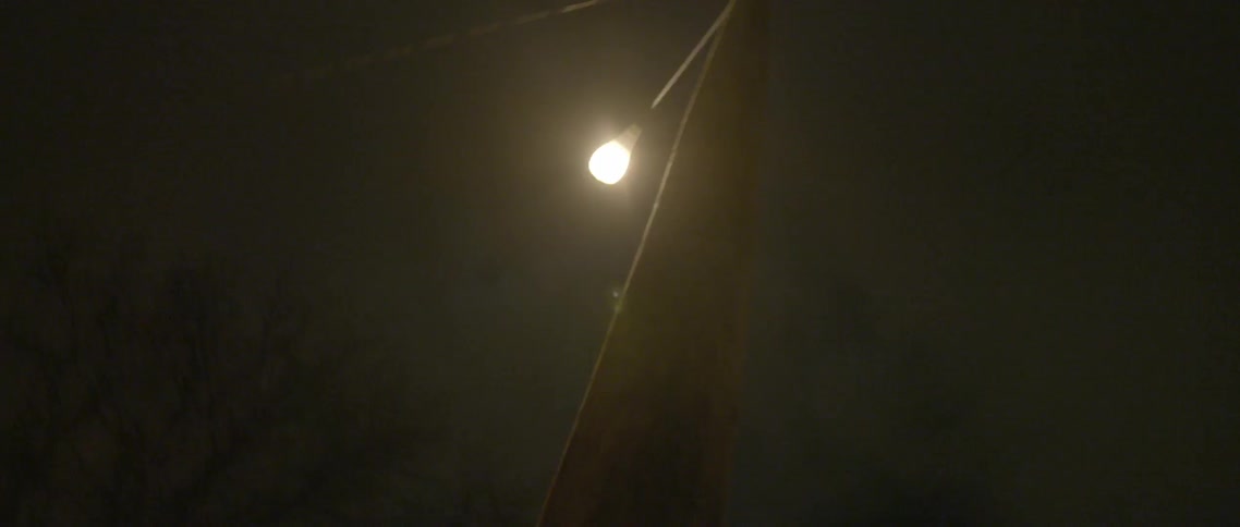A light post is partially lighting a night sky