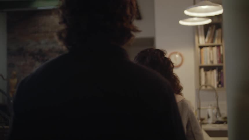 A man and woman walk into another home and two woman hug excitingly
