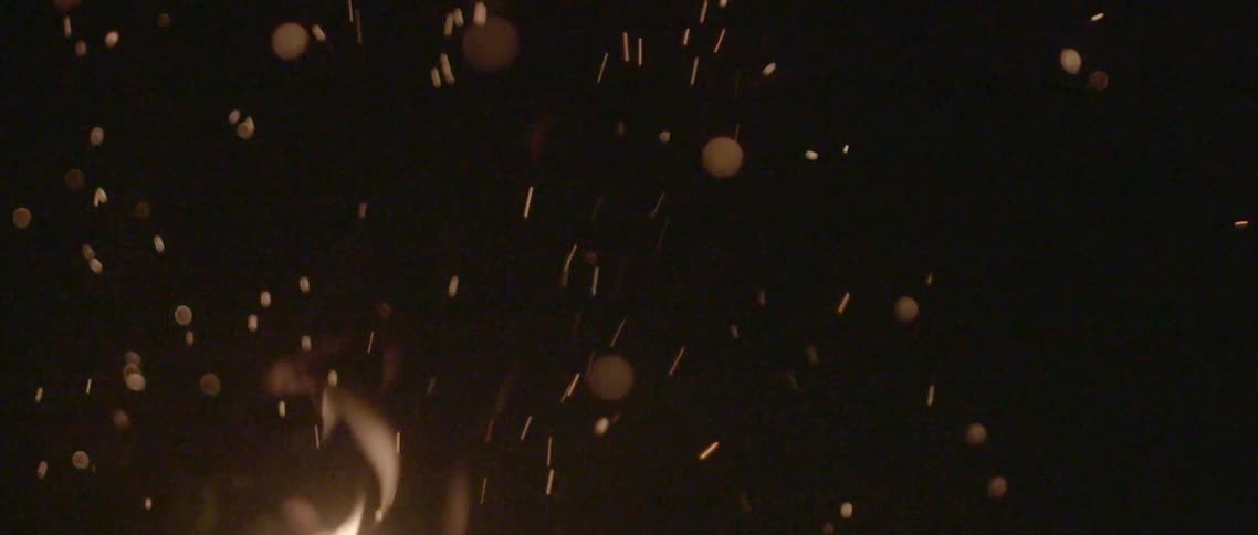 Flames and embers fill the dark night sky