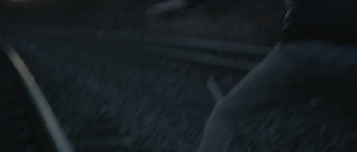 Person in a hoodie throwing  liquid down at night