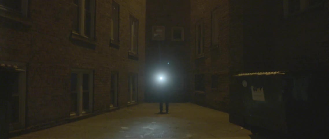 Person on a city street with a flashlight