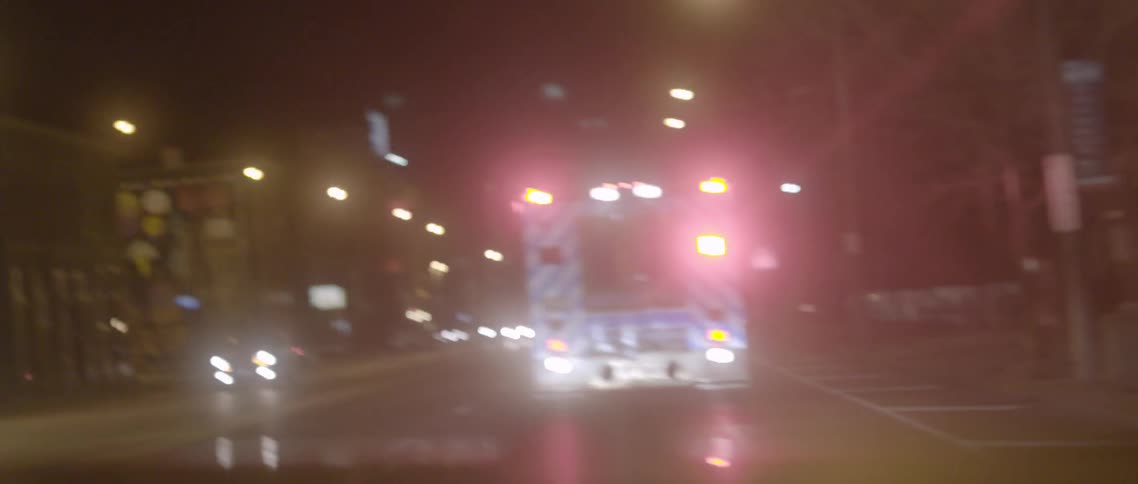A car is following an ambulance close at night