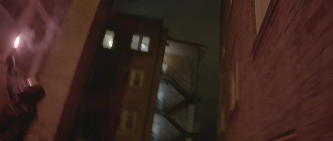 Very shaky picture of someone in a costume on a city street at night