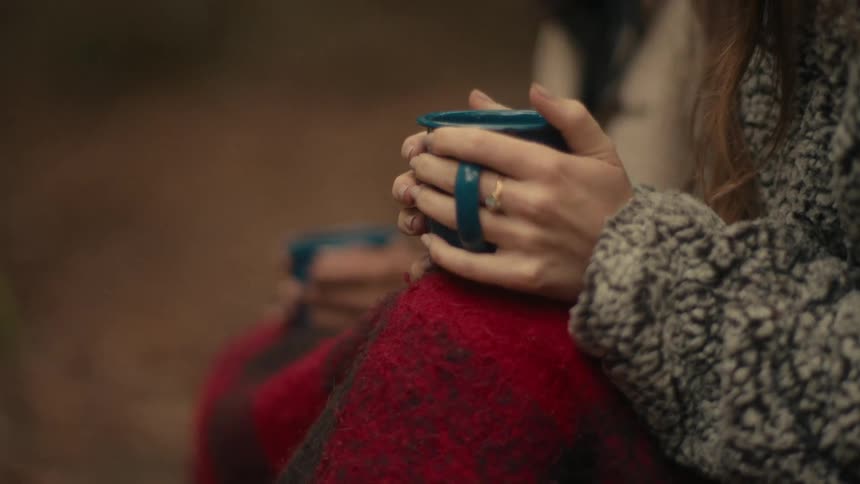 A woman sitting outdoors with a mug