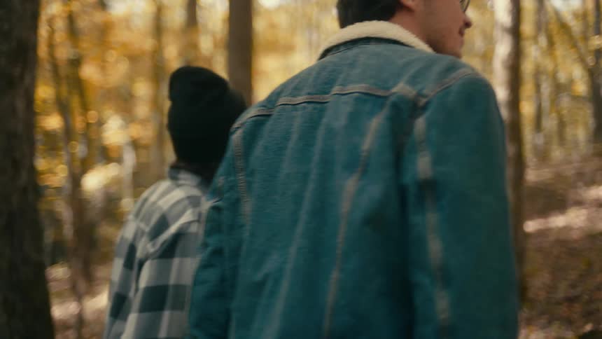 There are a bunch of people walking outside in the forest area