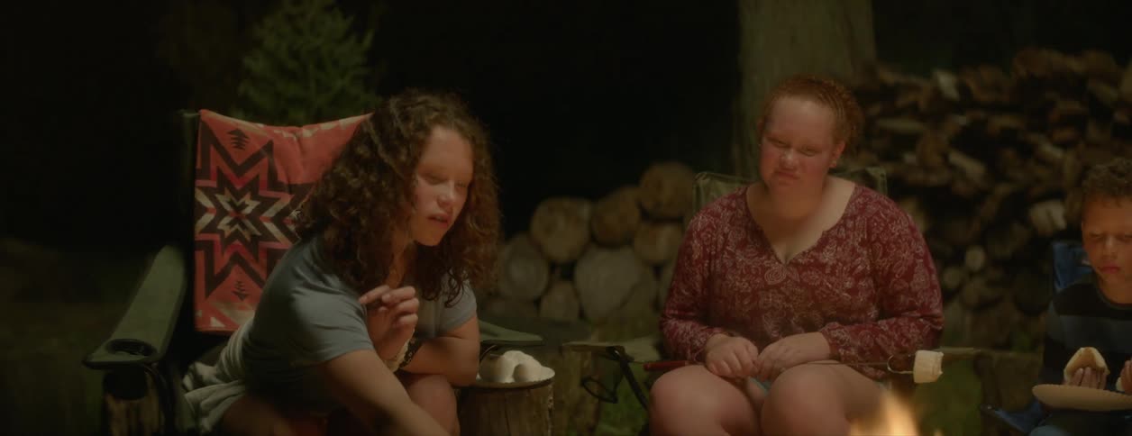 There are people that are camping outside and making smores