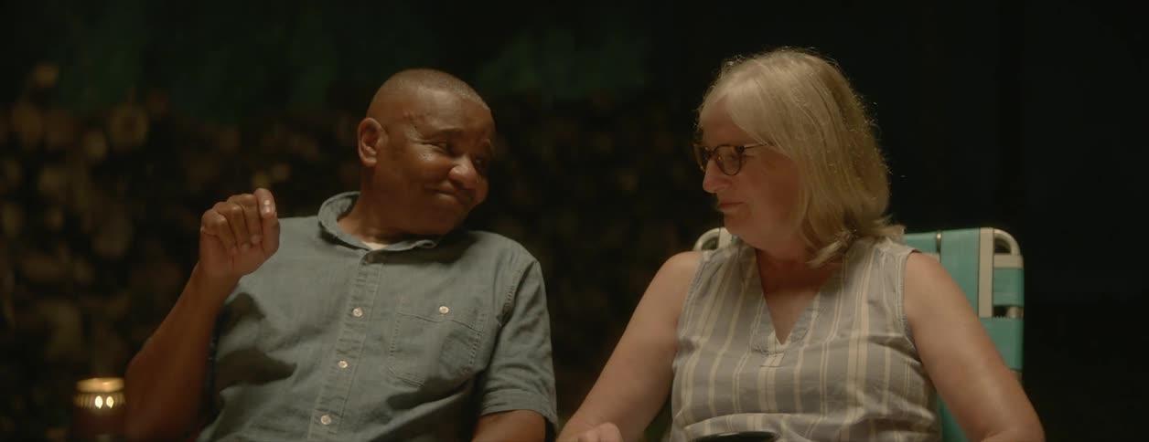 A couple is hanging out side at night and holding hands