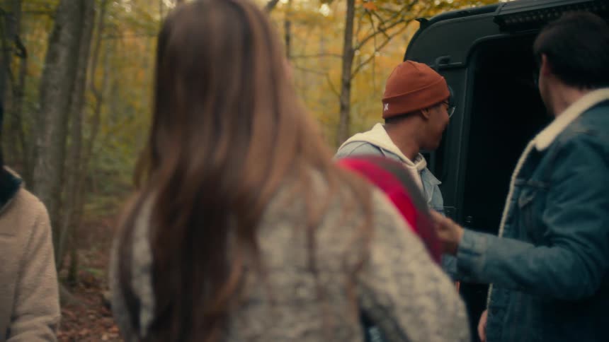 People are unpacking to camp in the woods