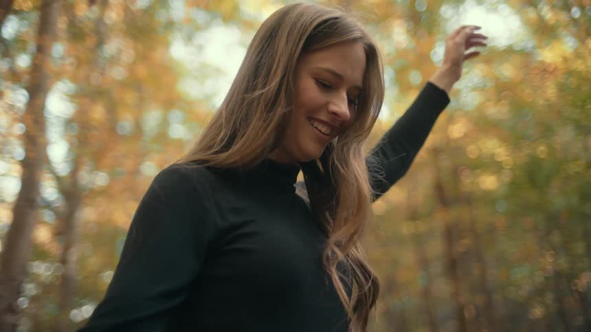 There is a young woman that is outdoors in the forest area