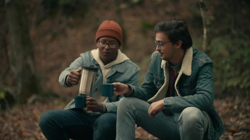 Two people are drinking coffee in the middle of the forest area