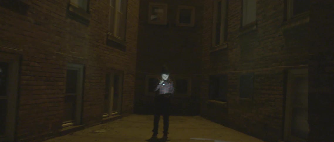 Boy reads a book outside with a flashlight then drops it to the ground