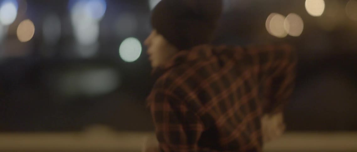 A boy is running as he looks behind him at night